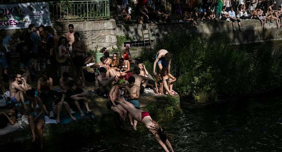 A swimmer dives into the Canal Saint-Martin, from an unapproved spot for swimming as France experienced a heatwave in Paris on 20 June 2026. - AFP - ARNAUD FINISTRE