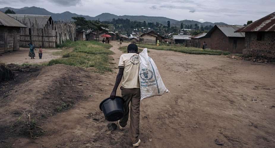A man carries supplies through Kishishe, eastern Democratic Republic of Congo. Fighting in eastern DRC has displaced millions of people as Rwanda and the DRC seek to implement a US-brokered peace agreement. -  Alexis Huguet / AFP