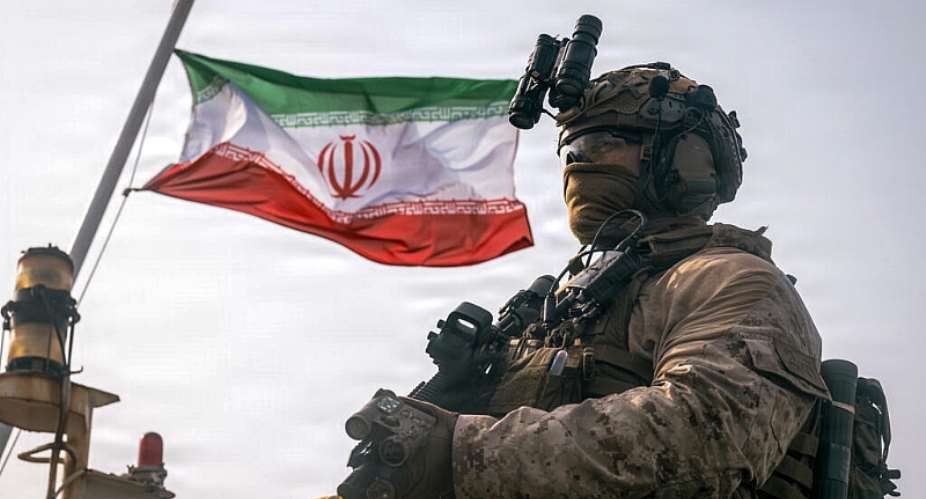 This image provided by the US Marine Corps shows an Iranian flag behind a Marine on July 16, 2026. -  Sgt. Joseph Helms, AFP