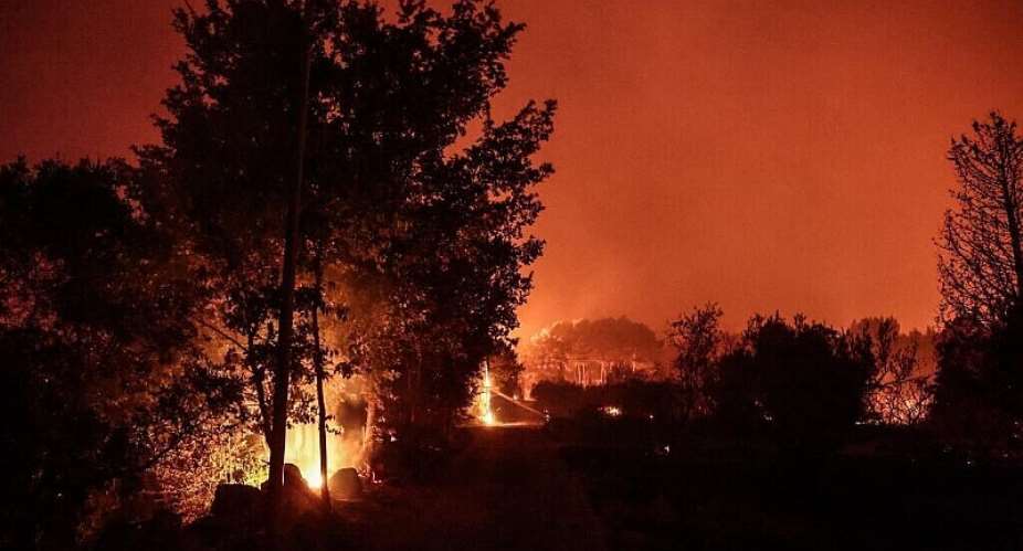 Vegetation in a residential neighborhood is engulfed in flames in Cotignac, southeastern France, on July 22, 2026. - AFP - THIBAUD MORITZ