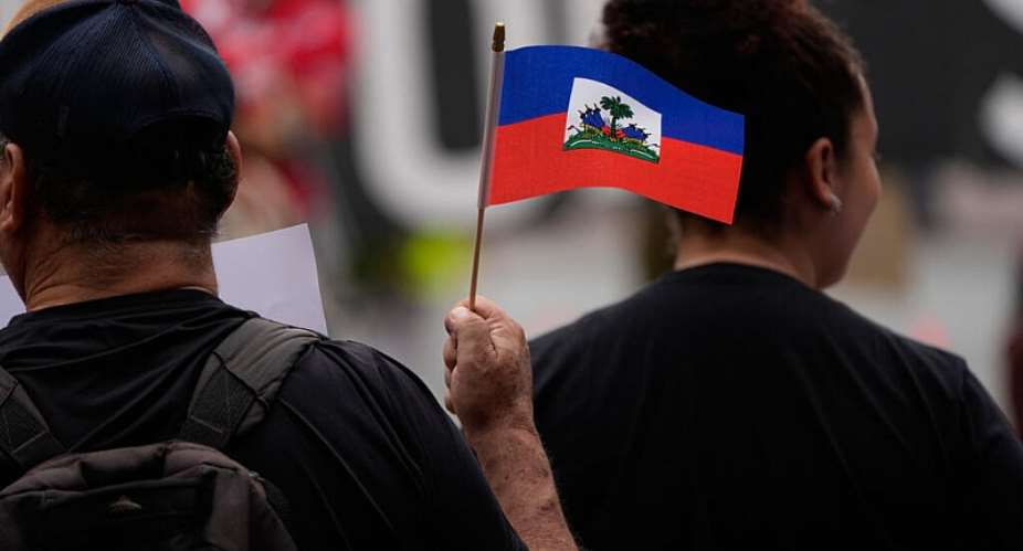 People in San Diego hold Haitian flags and signs during a rally in support of immigrants living in the United States with temporary protected status, or TPS, on 9 July 2026. -  Gregory Bull / AP