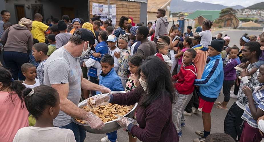 Children receive biscuits and other foods from the Groundbreakers community feeding programme in Ocean View, Cape Town. - Source: EPA-EFENic Bothma