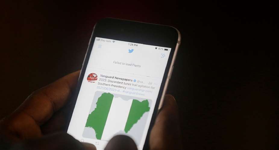 A man uses his mobile phone to read headline news on Twitter in Lagos, Nigeria, on June 7, 2021. Two Nigerian journalists talked to CPJ about the government's ongoing Twitter ban. AP PhotoSunday Alamba