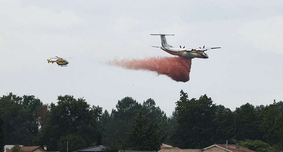 This photograph shows a Bombardier Dash 8 Q400 MR aircraft (R) dropping fire retardant over a forest near Marcheprime, some 30km from Bordeaux, on July 27, 2026. -  Alain Jocard, AFP