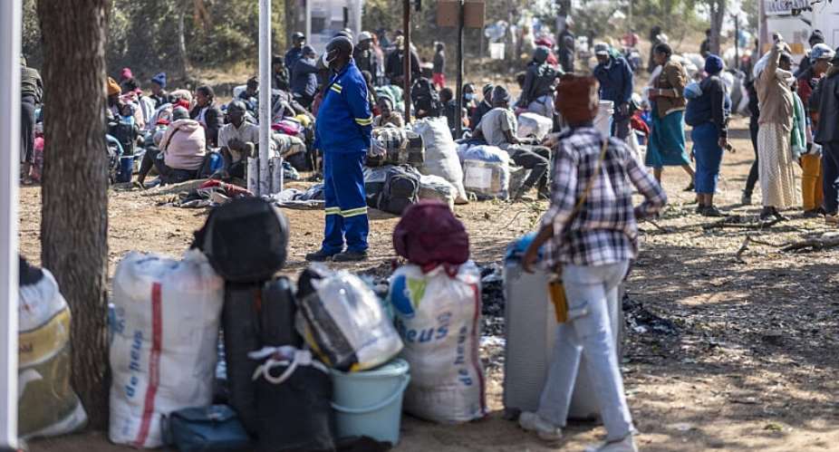 Hundreds of Zimbabwean citizens waiting to be transported home after fleeing South Africa at a repatriation reception camp in Beitbridge, Zimbabwe, 9 July 2026. - AFP - ZINYANGE AUNTONY