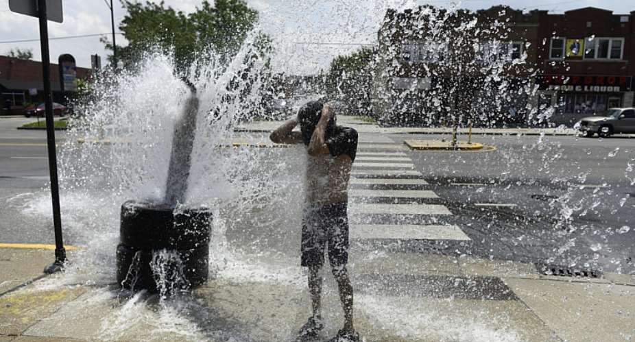 A person cools off with water from an open fire hydrant during a heat wave on the West Side of Chicago, Illinois. Human-caused climate change can amplify El Ninos associated effects because a warmer ocean and atmosphere increase the availability of energy and moisture for extreme weather events. -  Octavio Jones, AFP