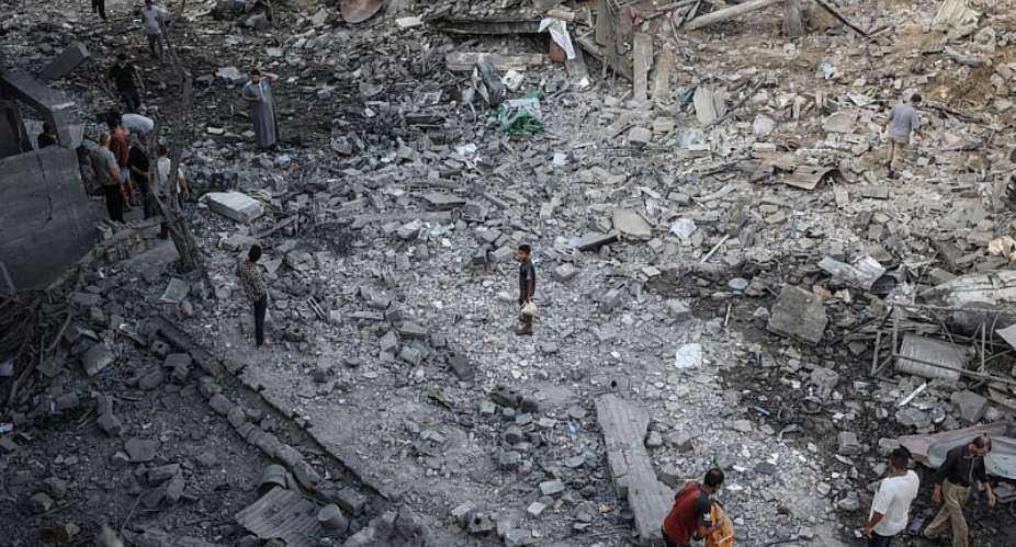 Palestinians inspect destroyed buildings after they were targeted by Israeli strikes the previous night in Deir al Balah, central Gaza Strip on July 29, 2026. -  Eyad Baba, AFP