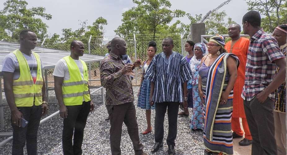 Group comprising USAIDGhana representatives, Chiefs and Global communities representatives admiring both the solar panels and the electricity change over component of the Tuna water system
