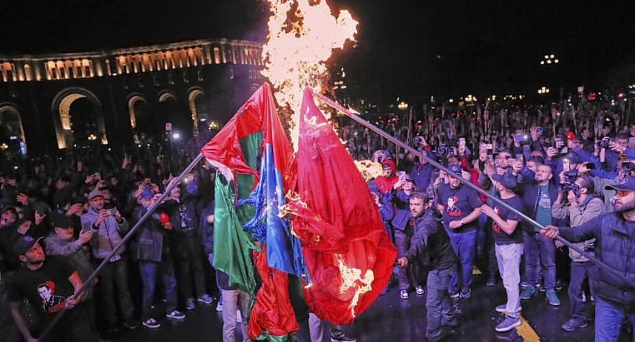 People burn representations of the Turkish and Azerbaijani flags during a demonstration marking the 110th anniversary of the Armenian genocide in Yerevan, Armenia, on 23 April 2025. - AP - Hayk Baghdasaryan