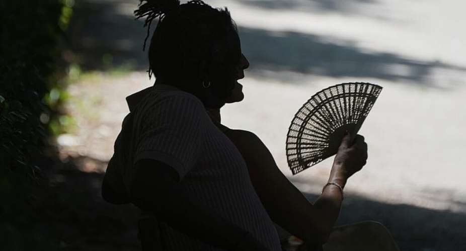 A man fans himself as he rests on a hot day in Retiro Park in Madrid, Spain, 28 June, 2025. - AP - Paul White