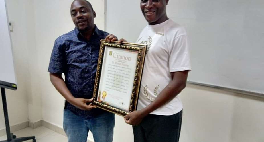 Mr. Yahaya Alhassan right presenting a certificate of honour to Dr. Thomas Buabeng