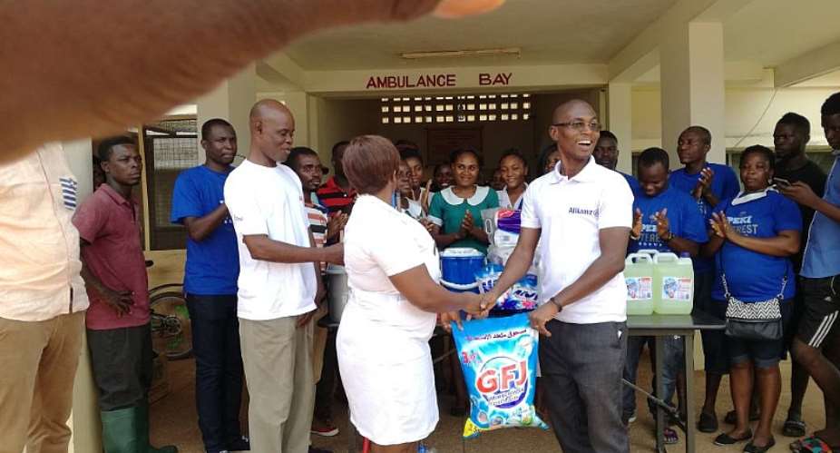 Dr Dela Ocloo, Medical Superintendent Of Peki Government Hospital In White T- Shirt With The Senior Nursing Officer Receiving The Items From Mr Elom Ohene