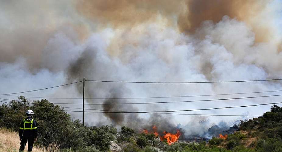 Smoke rises in the air as a firefighter inspects a wildfire near Ille-sur-Tt, southern France, 5 July 2026. -  Matthieu Rondel/AFP