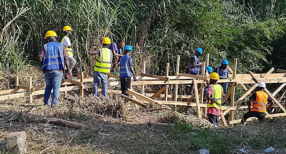 Workers putting up wooden support structures at the site