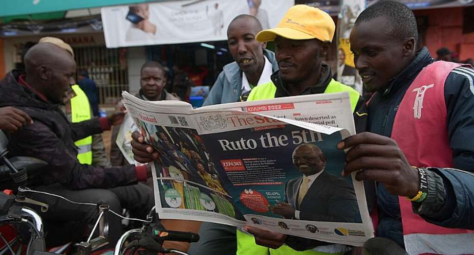 A Kenyan reads national daily newspaper The Standard, with a headline reporting the election of Kenyas 5th President elect William Ruto, in Eldoret, in August 2022. - AFP - SIMON MAINA