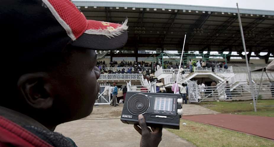 A party agent listens to the radio as electoral officials confirm and tally votes from polling stations  in Nairobi, Kenya in 2007.  - Source: Stephen MorrisonEPA