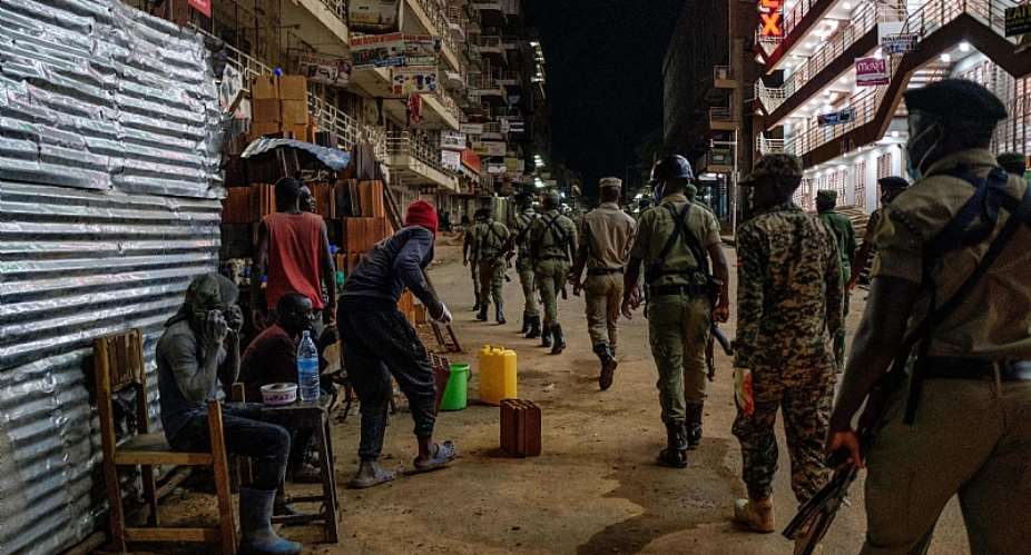 Ugandan police officers and members of a paramilitary force patrol the capital Kampala during the curfew.  - Source: Sumy SaduriniAFP via Getty Images