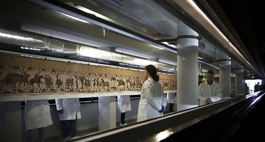 Workers and volunteers prepare to pack the Bayeux tapestry to transfer to the British Museum, at the Bayeux Tapestry Museum, in Bayeux, northwestern France, Thursday, Sept. 18, 2025. - AP - Lou Benoist