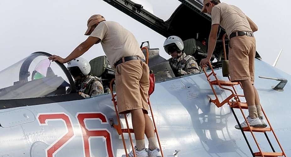Russian ground staff members check on a Sukhoi Su-30 fighter jet at the Hmeymim air base near Latakia - REUTERS