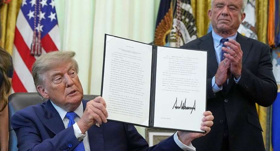 President Donald Trump holds a signed executive order about vaccines as Health and Human Services Secretary Robert F. Kennedy Jr. watches on August 10, 2026. -  Jacquelyn Martin, AP
