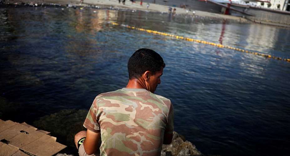 A migrant looks out at a beach following mass crossings of migrants on foot and by sea from Morocco into Spanish territory in Ceuta, Spain, August 1, 2026. -  Pedro Nunes, Reuters