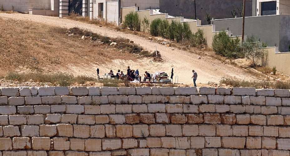 Israeli settlers gather in front of Palestinian houses in the village of Qusra, south of Nablus, in the West Bank, August 12, 2026. -  Zain Jaafar, AFP