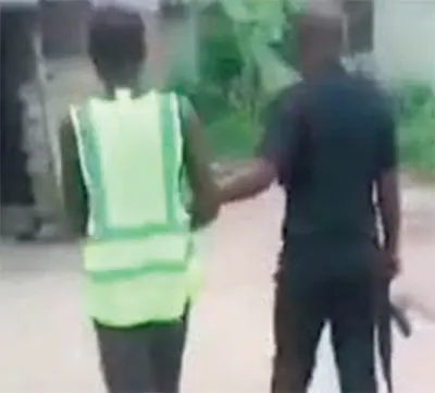 Dogbe in the grip of a police officer