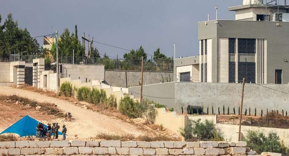 Israeli soldiers are seen as Israeli settlers set-up a tent just outside the entrance of a besieged Palestinian family home in the village of Qusra, south of the city Nablus, in the Israeli-occupied West Bank, on August 14, 2026. -  Jaafar Ashtiye, AFP