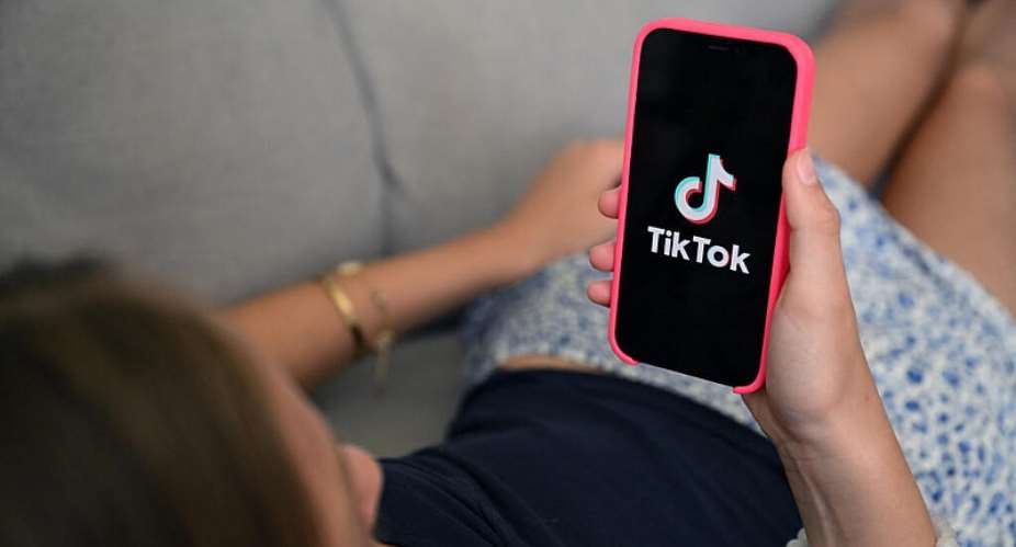 A teenager holds her smartphone displaying the logo of Chinese social network Tik Tok in Brussels on July 7, 2026. -  Nicolas Tucat, AFP
