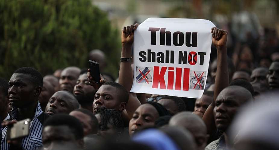 Christians hold signs as they march on the streets of Abuja in March 2020.  - Source: Photo by Kola SulaimonAFP via Getty Images