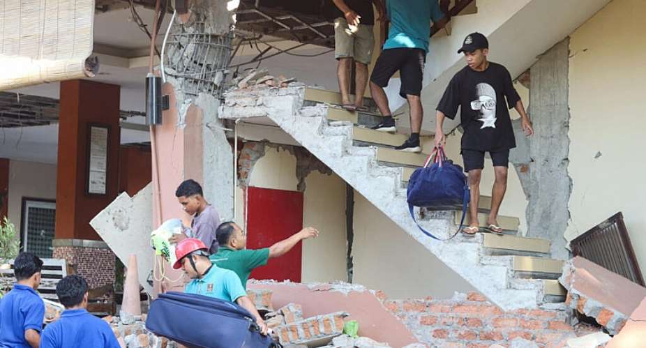 People evacuate from a collapsed building at the Jayakarta hotel in Labuan Bajo, Indonesia, following a powerful earthquake. -  Stringer, Reuters