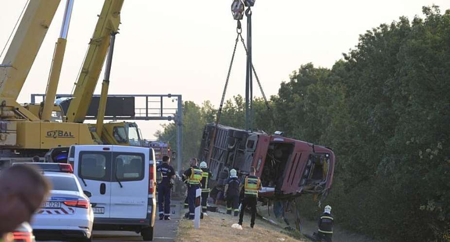 Rescue workers and other officials work at the wreckage of an overturned Polish tourist bus about 150 km east of the Hungarian capital Budapest, on August 16, 2026. -  Zoltan Mathe, AFP