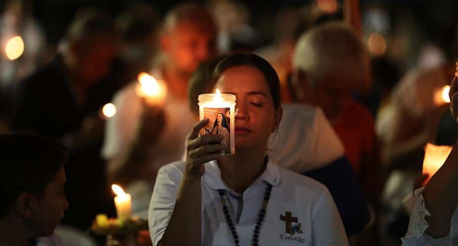 A woman holds a candle during a vigil for earthquake victims in Cali, Colombia on August 15, 2026. -  Santiago Saldarriaga, AP