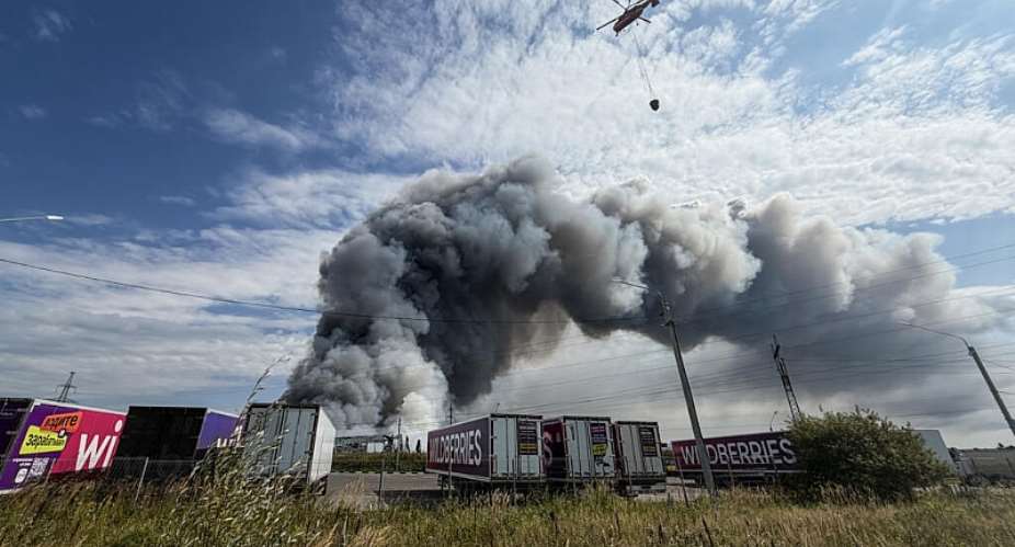 A firefighting helicopter prepares to drop a load of water during a fire at Russian e-commerce firm Wildberries logistics complex near the town of Podolsk, outside Moscow on August 16, 2026. -  Tatyana Makeyeva, AFP