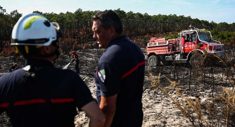 A firefighter sprays foam on burnt trees and plants in the forest of Le Grand Crohot, in Lege-Cap-Ferret, southwestern France on 1 August 2026. - AFP - ROMAIN PERROCHEAU