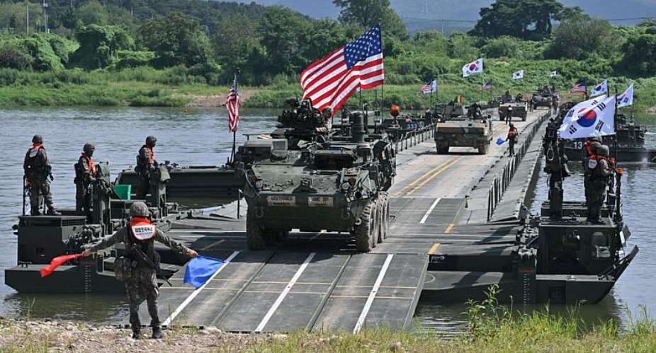 A US Stryker infantry carrier vehicle (C) crosses a river over a floating bridge during a South Korea-US joint river-crossing drill as part of the annual Ulchi Freedom Shield military exercise in Yeoju on August 27, 2025. -  Jung Yeon-Je, AFP