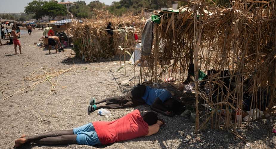 Migrants rest next to makeshift shelters in Ceuta on August 15, 2026. -  Jorge Guerrero, AFP