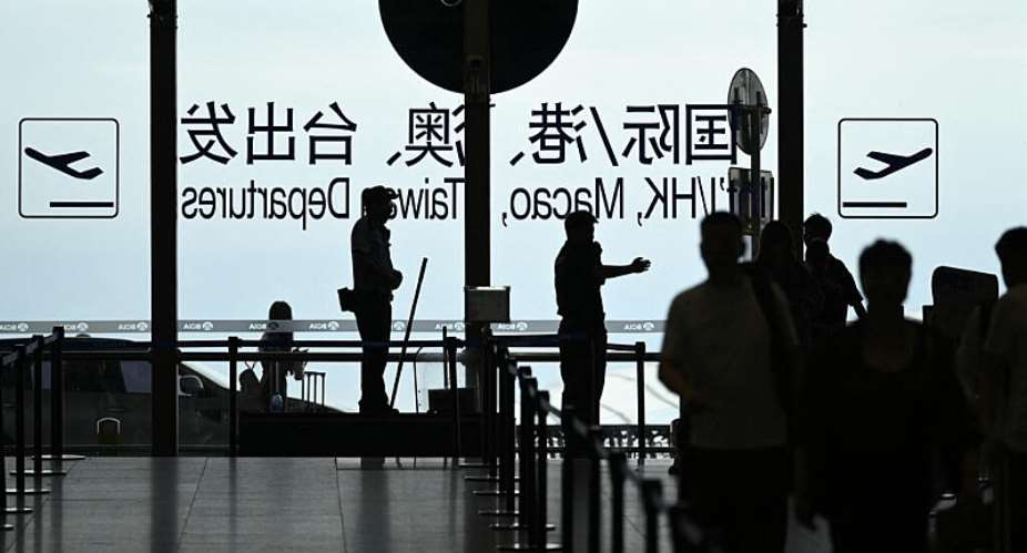 File photo: A security guard guides passengers at Beijing International airport on July 6, 2025. -  Wang Zhao, AFP