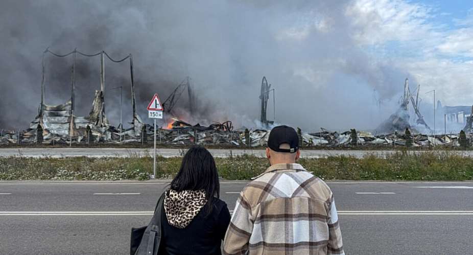 People watch the burning Wildberries warehouses following a Ukrainian drone attack, according to the regional governor, in the course of the Russia-Ukraine conflict, in Koledino, Moscow Region, Russia August 16, 2026. -  Stringer, Reuters