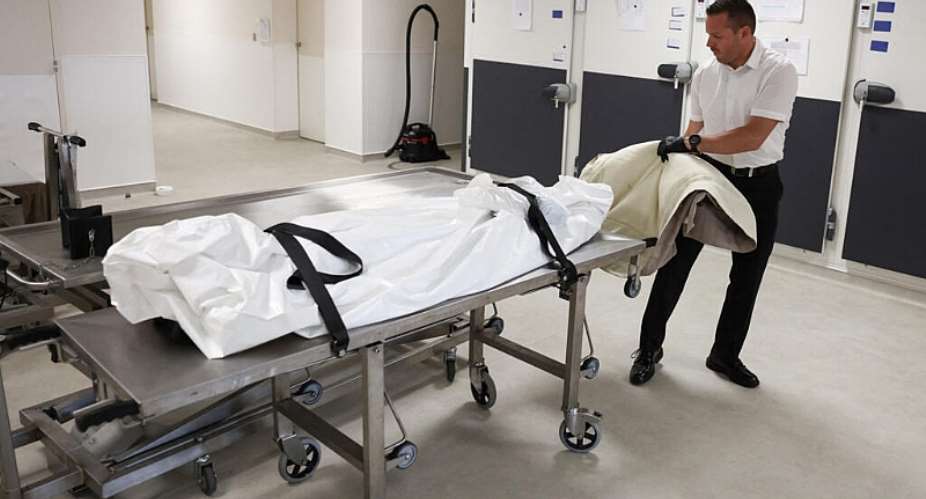 An undertaker and the body of a 93-year-old man who died in hospital in a mortuary in Orleans, 15 July 2026. -  Tom Nicholson/Reuters