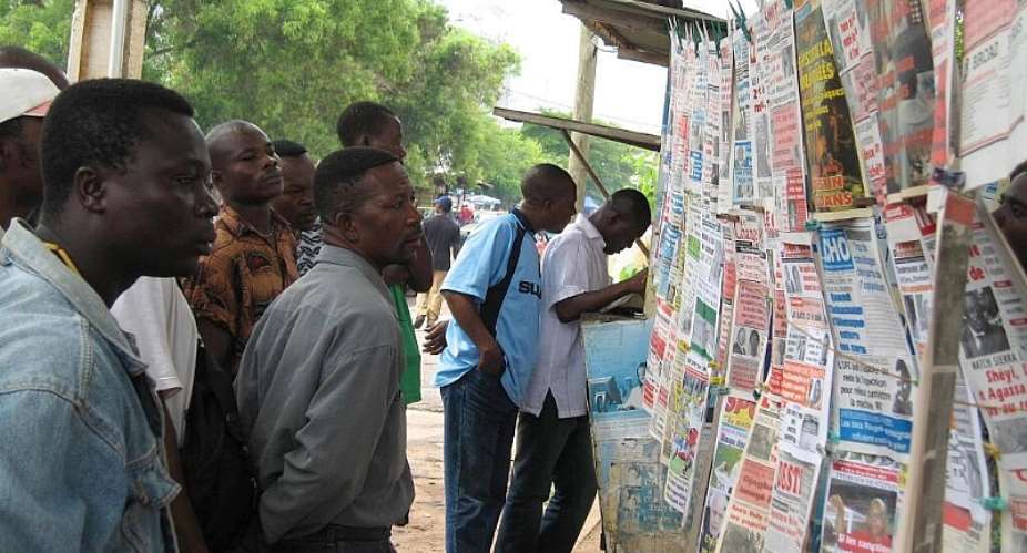 People read newspaper headlines in Lom, Togo. The Togolese government has been holding two French journalists and their local fixer in custody since late July. -  AFP/EMILE KOUTON