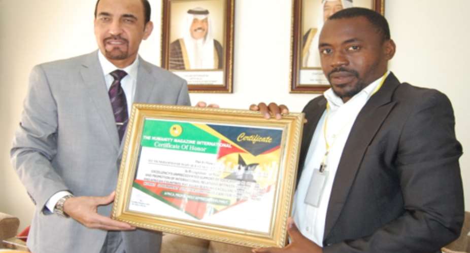 Ambassador Mohammed Hussain Al-Failakawi R receiving a certificate of honour from Yahaya Alhassan L