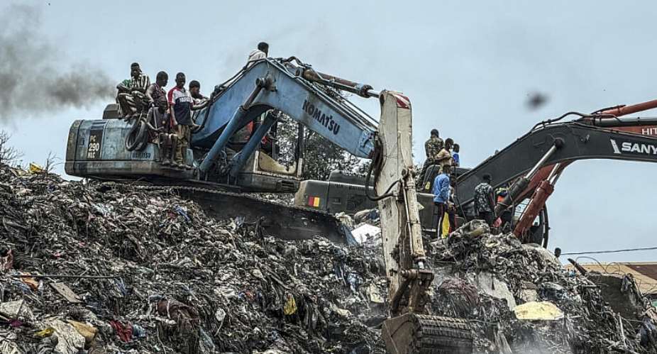 Residents and rescue workers use an excavator to search for bodies following a landslide that occurred overnight at the Dar-es-Salam landfill in Conakry, Guinea, on 23 August 2026. - AFP - -