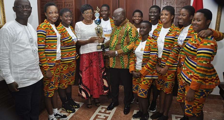 President Nana Addo Dankwa Akufo-Addo receiving a trophy won by the Robotics Team from Mrs Sylvia Isabella Laeryea 4th left. With them are the students