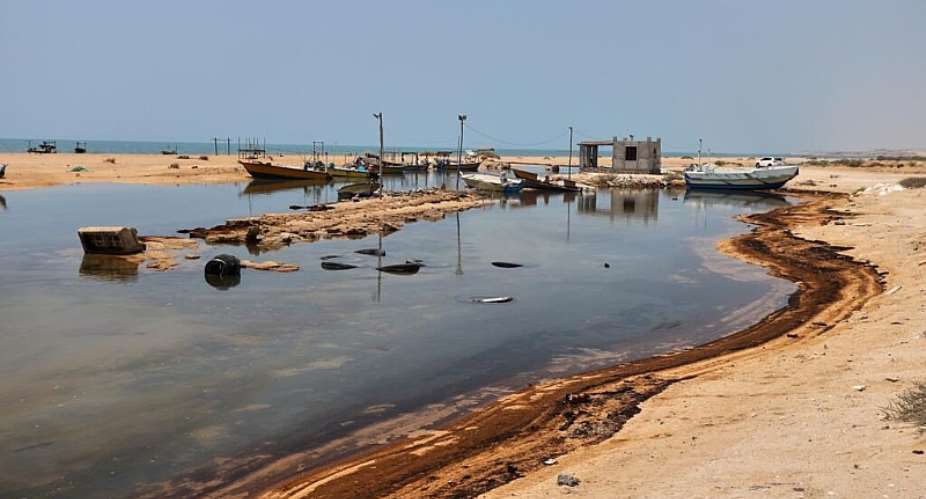 Oil residue lines the shore near fishing boats on Irans Qeshm Island in the Strait of Hormuz on August 13, 2026. -  Amirhosein Khorgooi, AP