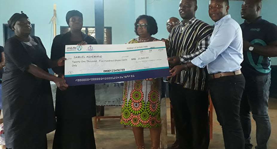 Officials of Milife and GNAT right presenting the dummy cheque of GH21,500 to the family of the deceased