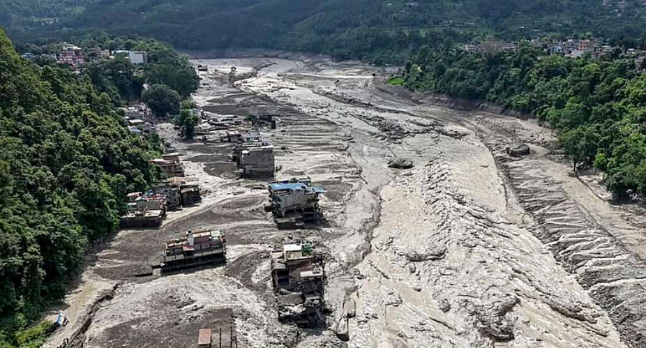 This aerial view shows houses laying partially submerged in muddy water along a riverside after flash floods at Trishuli Bazar in Nepals Nuwakot district on August 26, 2026. -  Prabin Ranabhat, AFP
