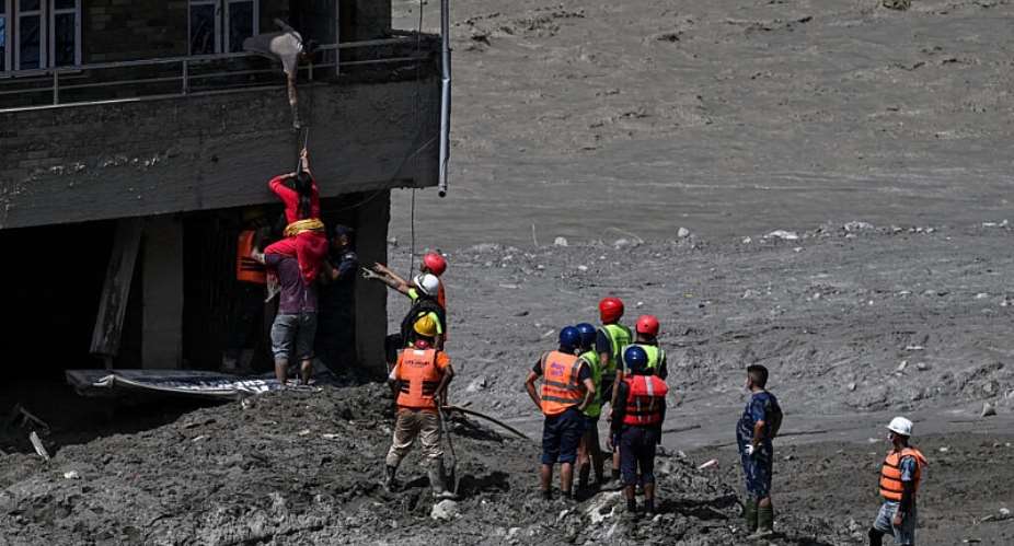 Police personnel rescue stranded residents from houses lying deluged in sludge after flash floods at Trishuli in Nepals Nuwakot district on August 27, 2026. -  Arun Sankar, AFP