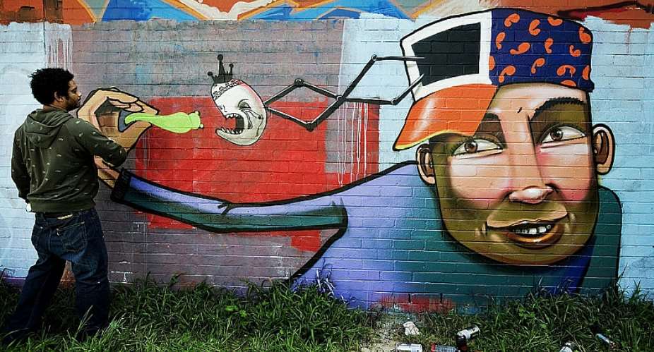 Graffiti artist Falko Starr finishes a mural in the Cape Flats area of Cape Town. - Source: GIANLUIGI GUERCIA/AFP via Getty Images