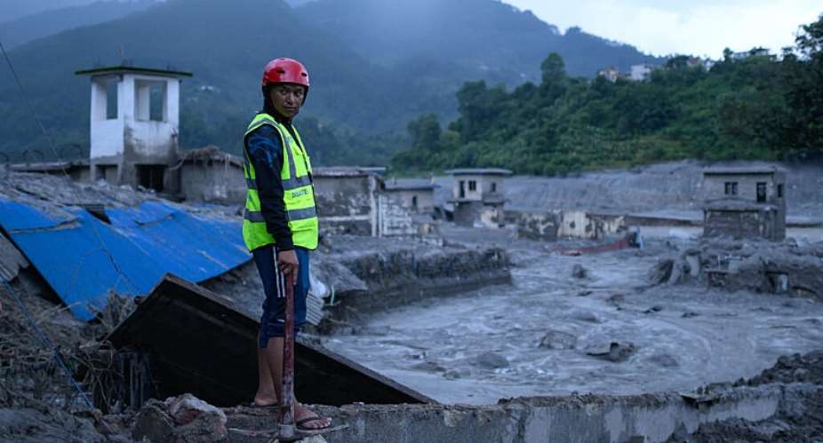 A rescue worker looks on at the site of damaged buildings in the aftermath of flash floods at Trishuli Bazar in Nepals Nuwakot district on August 29, 2026. -  Manan Vatsyayana, AFP